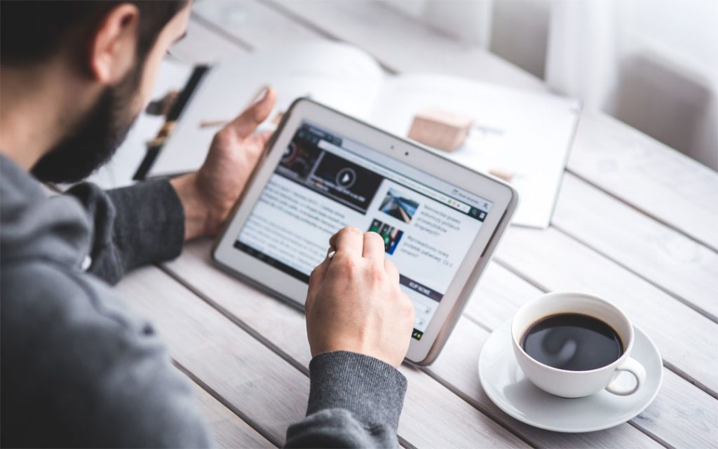 man with screen and coffee cup