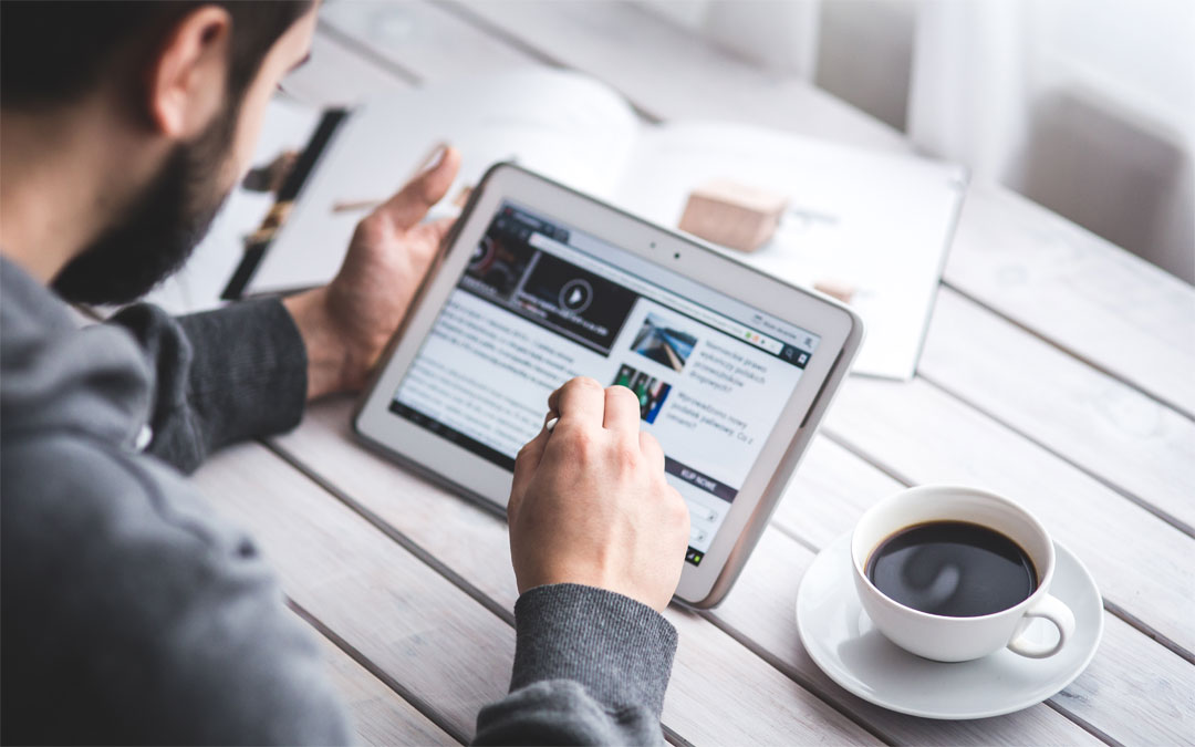man with screen and coffee cup