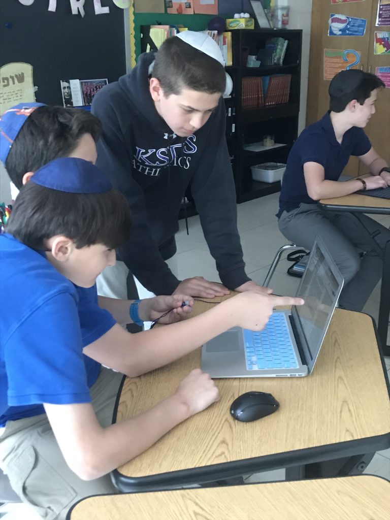 Krieger Schechter middle school students (Left to right) Sam A., Jackson M., Noah B. and Jacob T. gather around a computer