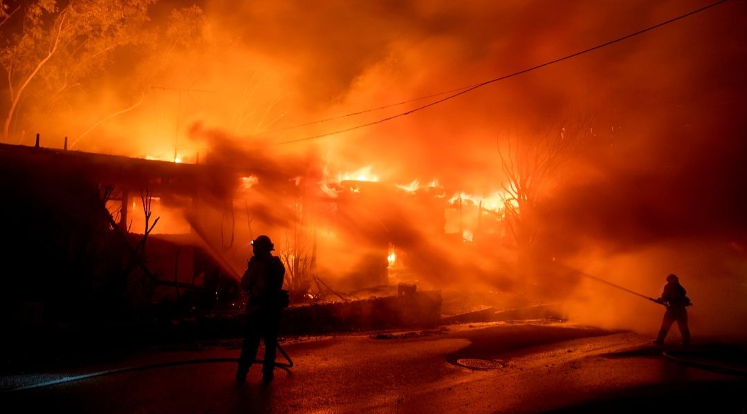 Firefighters work to contain the Getty Fire as it burns homes in the Brentwood Heights neighborhood of Los Angeles on Oct. 28. (Brian van der Brug/Los Angeles Times via Getty Images)