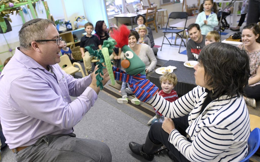 Rabbi Etan Mintz, left, and music teacher Becky Gordon, right, lead a program during the "Sukkot Under the Stars" event at Beth El preschool in Federal Hill. (Photo by Steve Ruark)