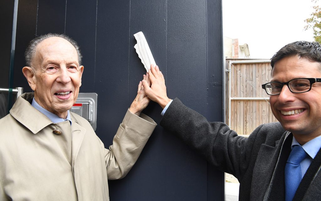 Beth Am congregant and benefactor Mark Joseph (left) and Rabbi Daniel Cotzin Burg participate in the mezuzah-affixing ceremony. (Photo by Jim Burger)ededication ceremony concluded with the affixing of a mezuzah at the grand entrance of the nearly century-old building. (Photo by Jim Burger)