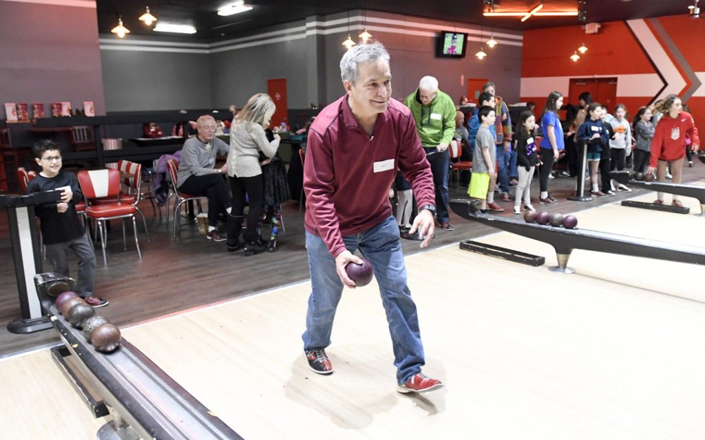 Bill London, of Owings Mills, bowls as his grandson Logan Harris, left, 7, of Pikesville watches during the Macks Center for Jewish Education's Saba-ba: Grandparents on the Go launch party at AMF Pikesville Lanes. The Saba-ba program brings together children and their grandparents. (Photo by Steve Ruark)