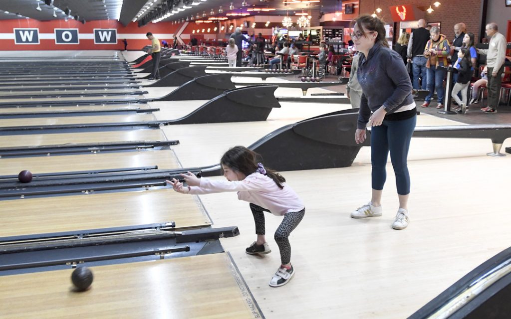 Jenna Densky, 6, bowls as her mother, Alissa Densky, of Pikesville, drops her off to spend time with her grandparents during the Macks Center for Jewish Education's Saba-ba: Grandparents on the Go launch party at AMF Pikesville Lanes. The Saba-ba program brings together children and their grandparents. (Photo by Steve Ruark)