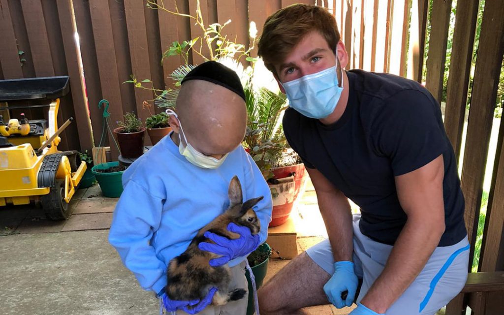 Pikesville High School student Evan Flaks (right) spends time with a young friend from Chai Lifeline.