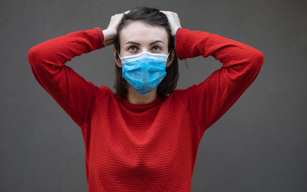 woman in mask holding head