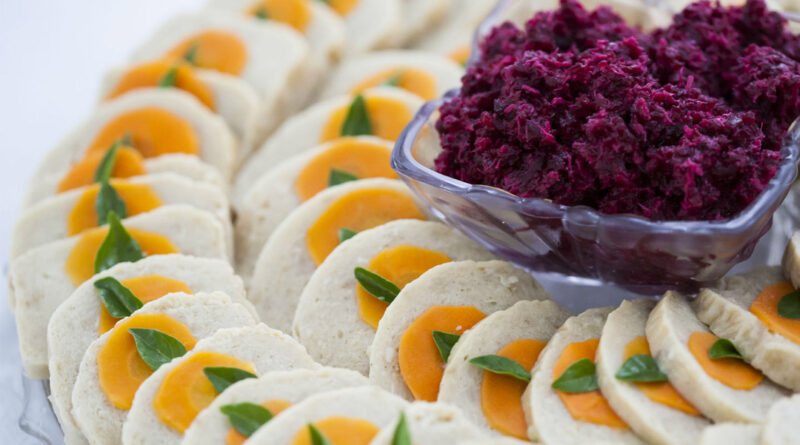 Sliced gefilte fish with carrot and horseradish.