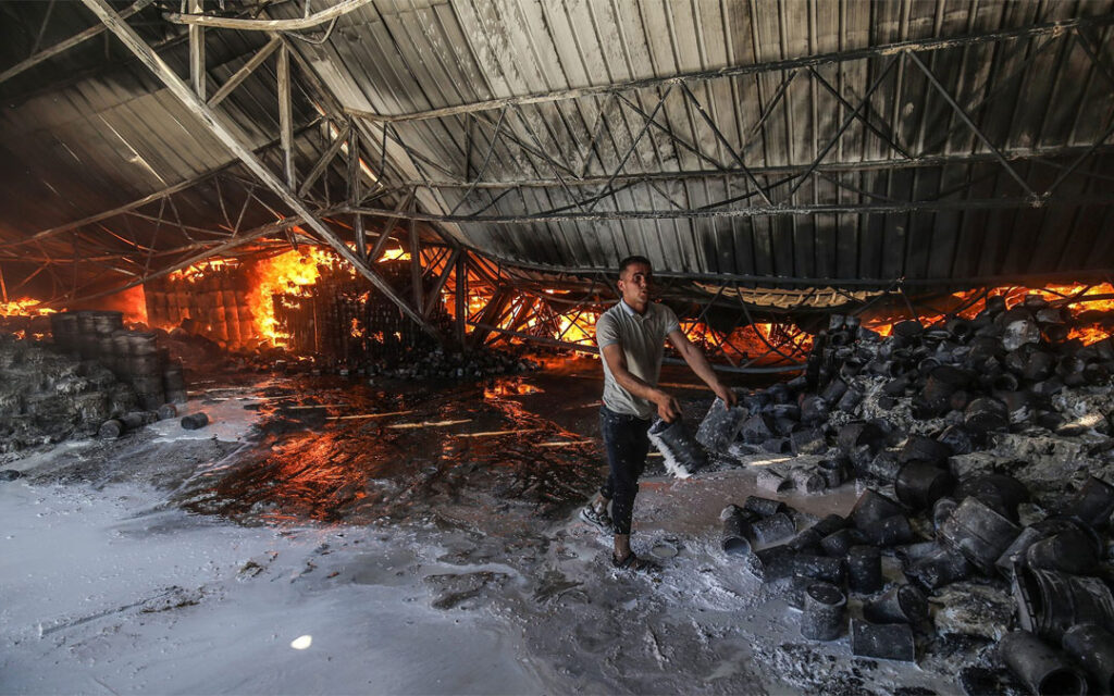 Firefighters attempt to extinguish a fire at a warehouse which was hit during an Israeli airstrike in Rafah, in the southern Gaza Strip, on May 18.