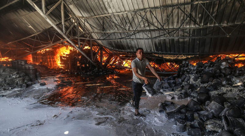 Firefighters attempt to extinguish a fire at a warehouse which was hit during an Israeli airstrike in Rafah, in the southern Gaza Strip, on May 18.