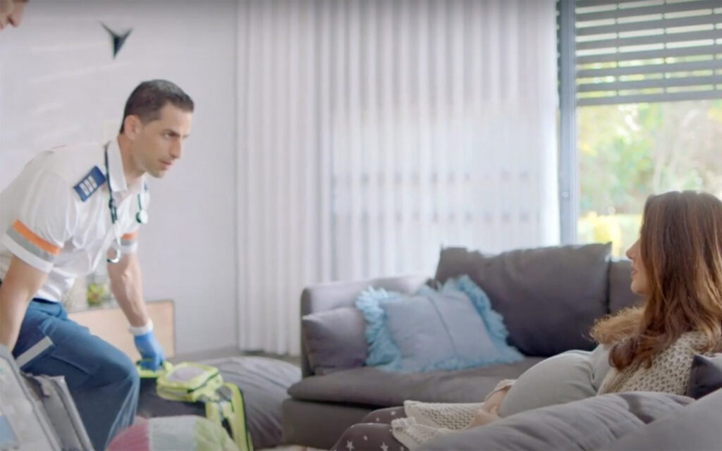 A paramedic with Magen David Adom, Israel's national emergency medical service, treats a pregnant woman in her home.