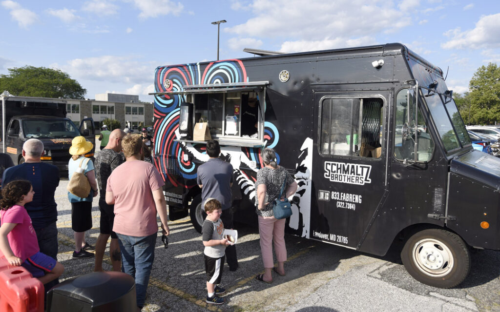 A crowd gathers around the Schmaltz Brothers food truck during Chizuk Amuno Congregation's SummerFest.