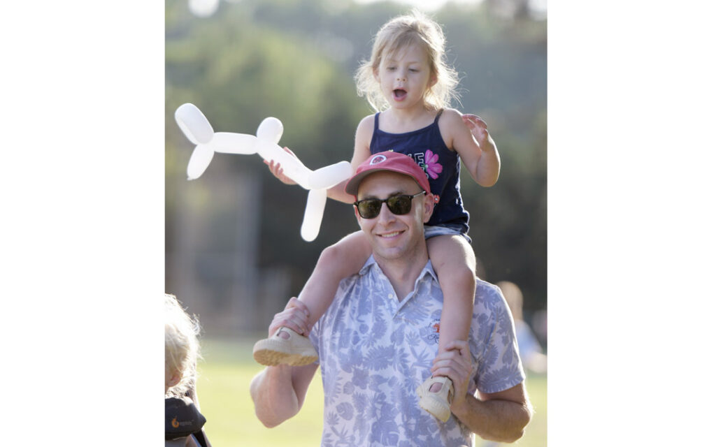 Ben Waller, of Lutherville, holds his daughter Emilia, 3, on his shoulders during Chizuk Amuno Congregation's SummerFest.