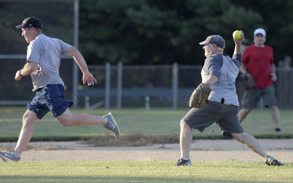 Alan Guttman, right, of Pikesville, throws out Dan Wahlberg, left, of Pikesville, during a pickup softball game at Chizuk Amuno Congregation's SummerFest.
