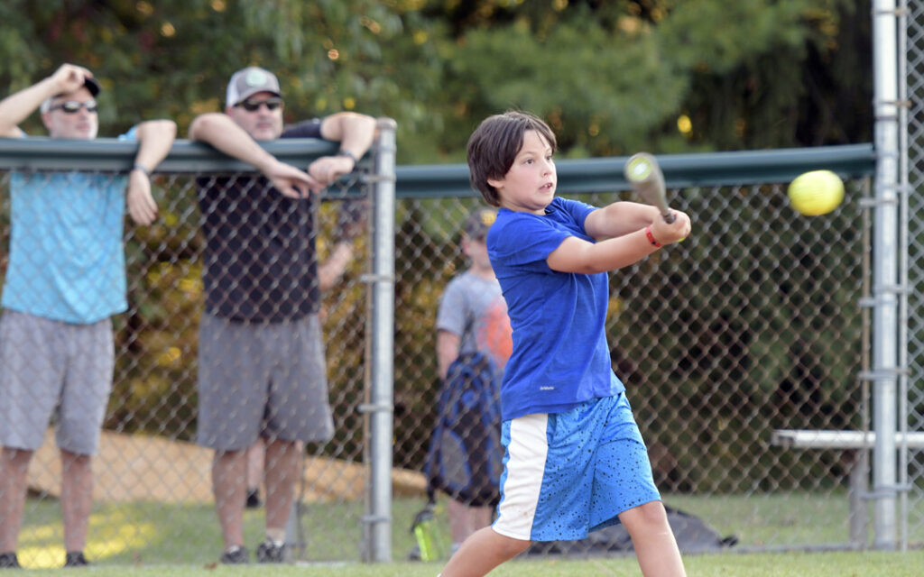 Ari Glock, 8, of Timonium, makes contact during a pickup softball game at Chizuk Amuno Congregation's SummerFest.