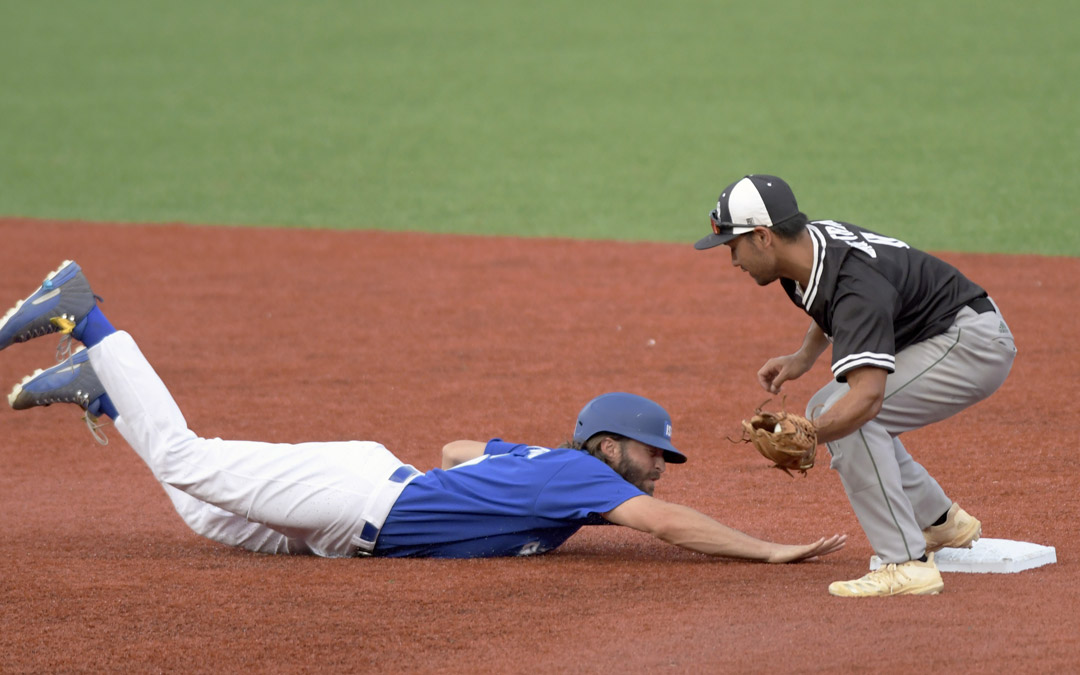 Team Israel's Zach Penprase dives safely back to second base under a tag from Keith Torres of the Cal Ripken Collegiate All-Stars during an exhibtion baseball game in Aberdeen. (Photo by Steve Ruark)