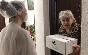 Employees from the Israel Electric Corporation deliver boxes of fresh fruit and vegetables to Holocaust survivors living in government-subsidized housing in the Haifa area.