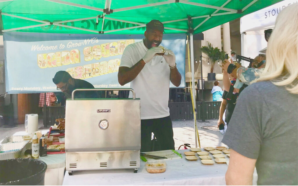 Amar'e Stoudemire, assistant coach of the Brooklyn Nets, samples one of his own signature Stoudemire Farms burgers at his booth at the Union Square Greenmarket in Manhattan