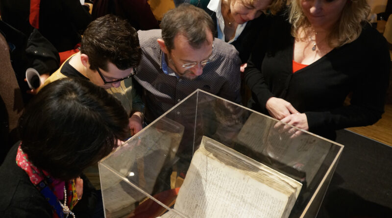 Scholars attending a 2015 Amsterdam symposium on whether to lift the order of excommunication against the philosopher Baruch Spinoza examine a copy of the original writ against him.