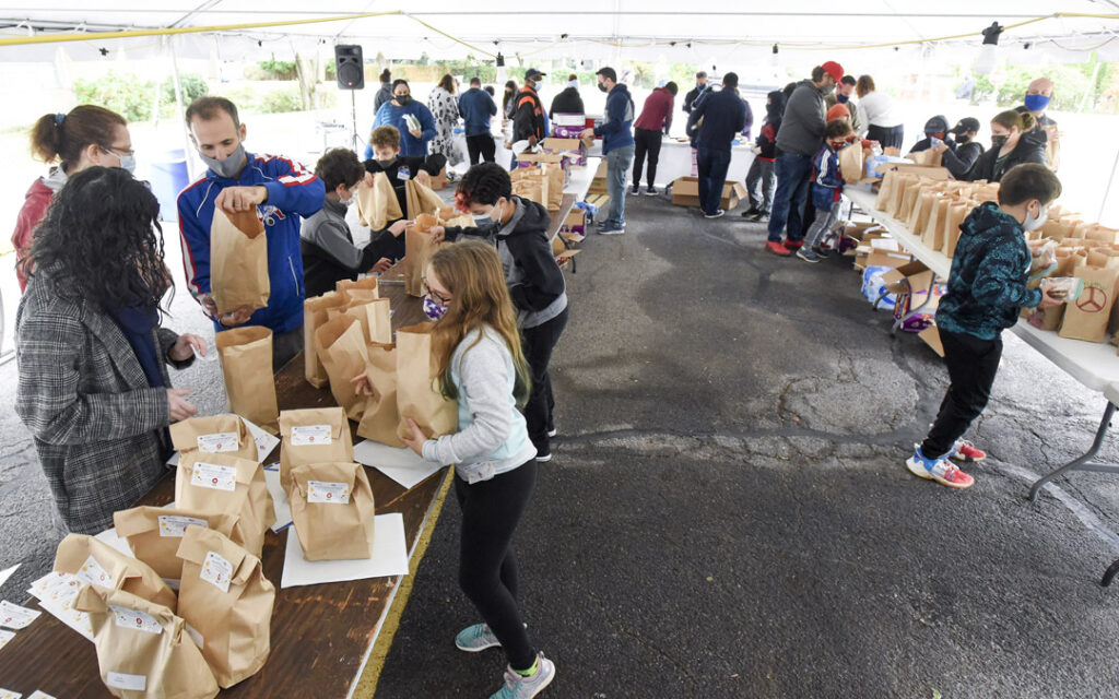 Volunteers pack lunches for people facing food insecurity during Posner JEM Religious School's family education event to support JVC's Bunches of Lunches program.