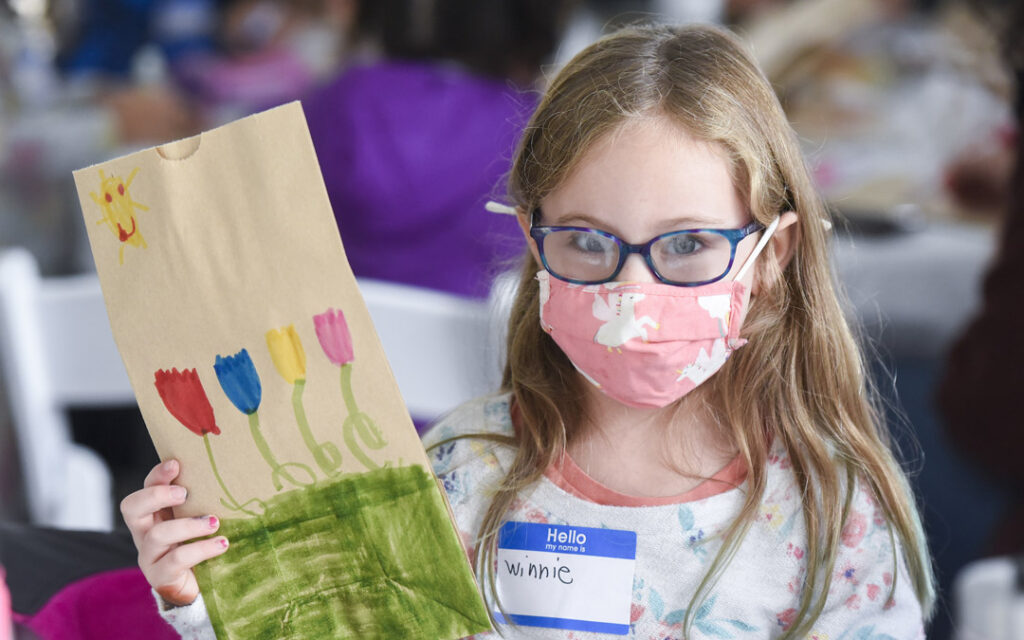 Winnie Pachino, 6, shows a lunch bag she decorated during Posner JEM Religious School's family education event to support JVC's Bunches of Lunches program.