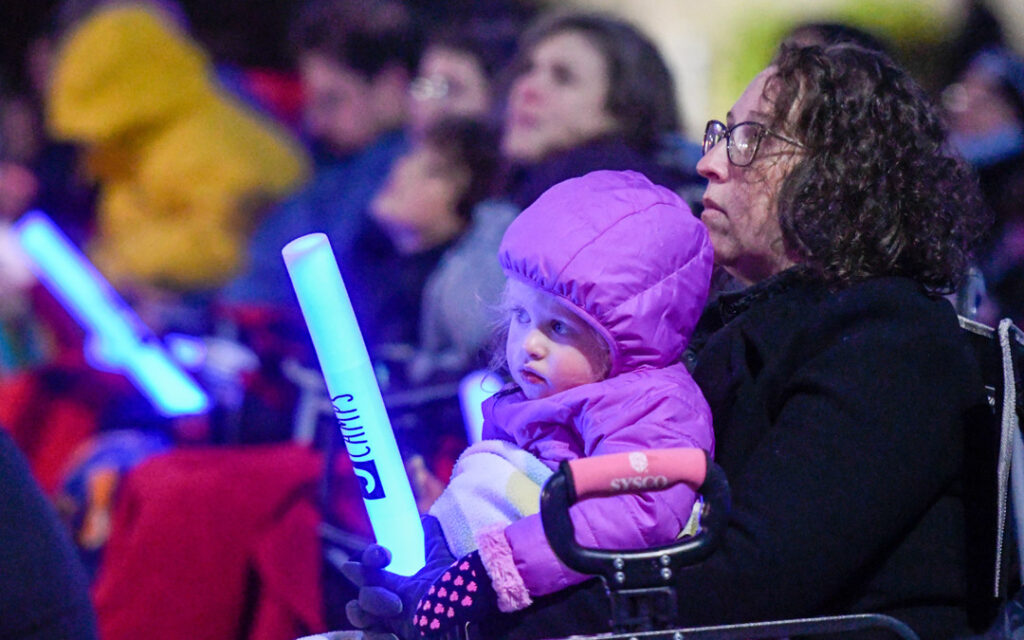 Elaine Irwin and her daughter, Eloise, 2, await the start of "Illumination Celebration: Chanukah Ignited" at the Owings Mills JCC. (Photo by Steve Ruark)