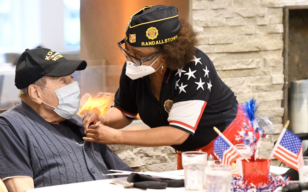 Army veteran Vanessa Deal (right), a service officer with American Legion Post 122, presents a pin of honor to seven-year U.S. Army veteran Marty Zuckerman, who served during the Korean War.