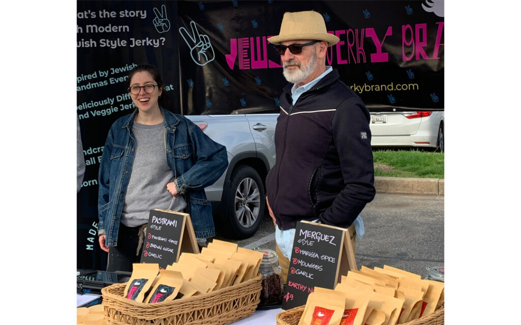 Adam Kaufman (right), founder of the Jewish Jerky Brand, works his booth at the 32nd Street Farmers Market in Waverly with his oldest daughter, Sophie.