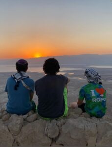 Max Riter (center) and a pair of friends take in the sunrise from the Israeli desert