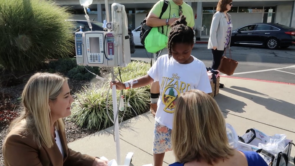 Becky Smith, EVP and Chief Revenue Officer and Sarah Ryan, AVP Community Engagement at SECU, and Noelle, a pediatric patient at Sinai