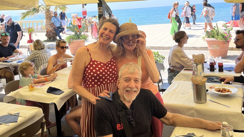 The author (standing, right) is shown dining here with her sister and father