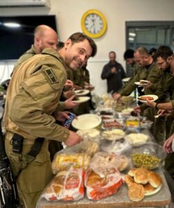 An Israeli soldier enjoy a barbecue meal, courtesy of ACHI