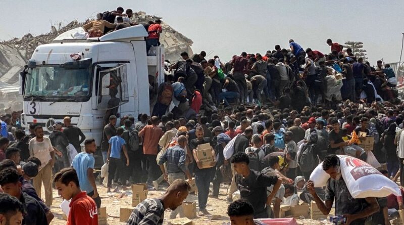 Displaced Palestinians carry food parcels