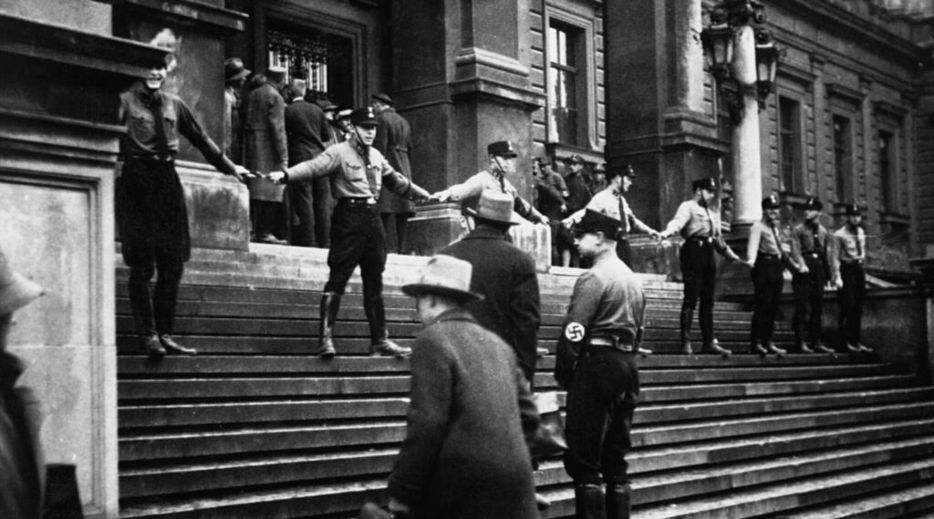 In 1938, Nazis are shown barring Jewish students in Austria from entering the University of Vienna